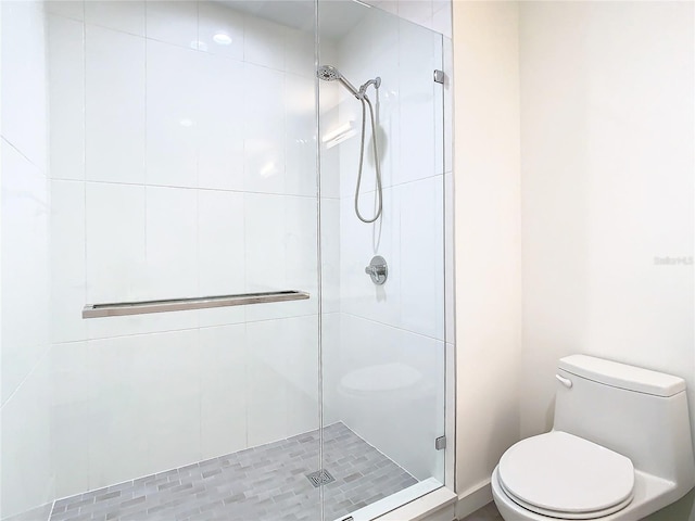 bathroom with toilet and a shower with shower door