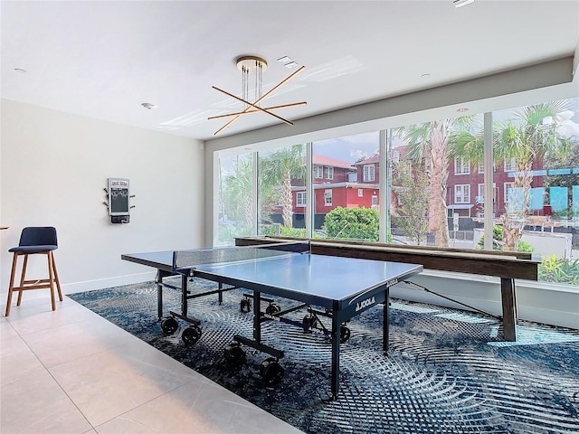 game room with tile patterned floors and a notable chandelier