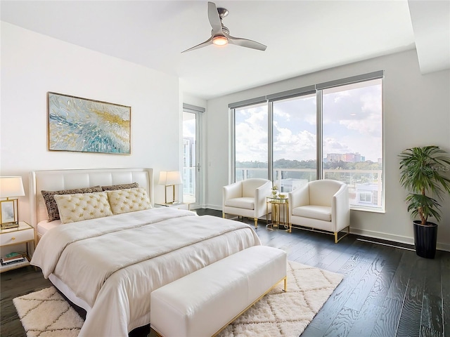 bedroom featuring ceiling fan, dark hardwood / wood-style floors, and multiple windows