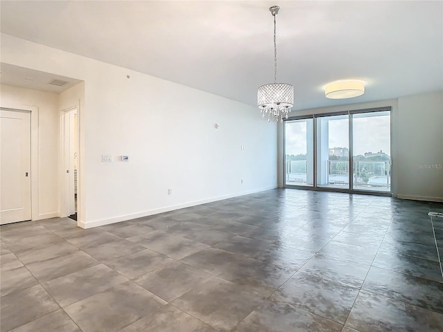 unfurnished room featuring a chandelier