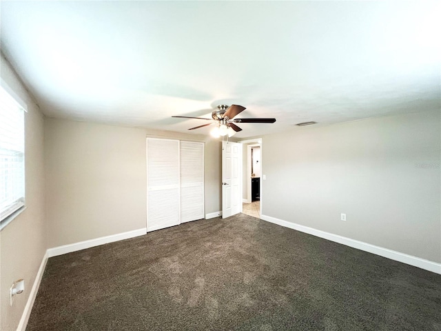 unfurnished bedroom featuring dark carpet and ceiling fan