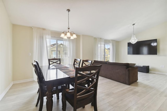 dining area featuring light hardwood / wood-style floors, a notable chandelier, and vaulted ceiling