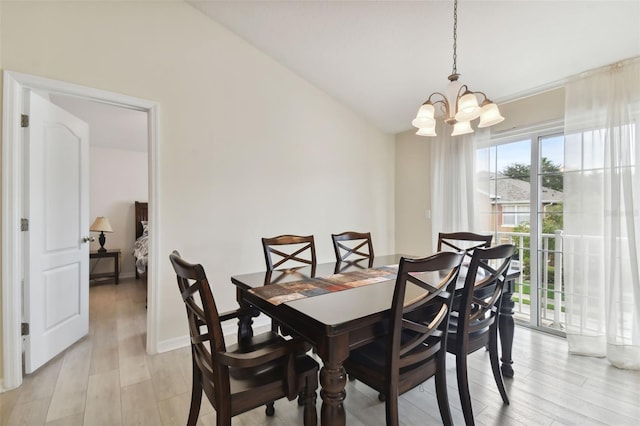 dining space with light hardwood / wood-style flooring, a chandelier, and lofted ceiling