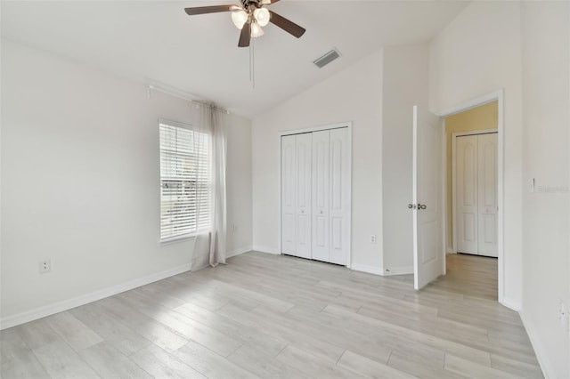 unfurnished bedroom with a closet, vaulted ceiling, light wood-type flooring, and ceiling fan