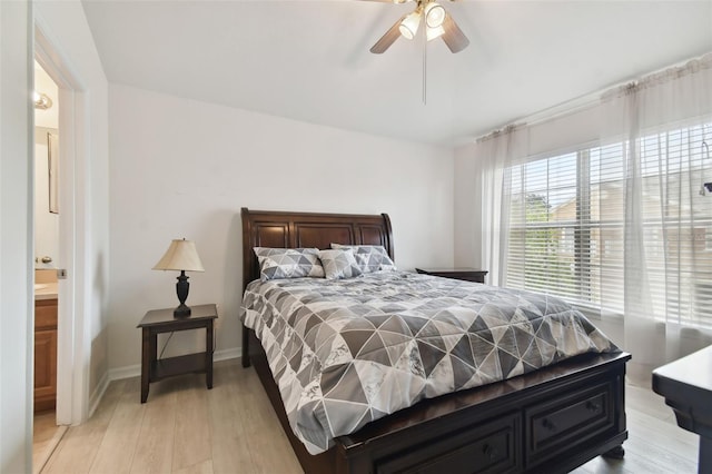 bedroom featuring light hardwood / wood-style floors, connected bathroom, and ceiling fan