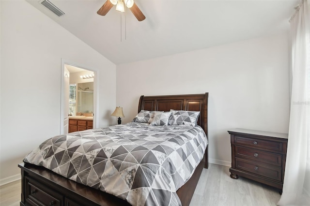 bedroom with light hardwood / wood-style floors, ensuite bathroom, vaulted ceiling, and ceiling fan