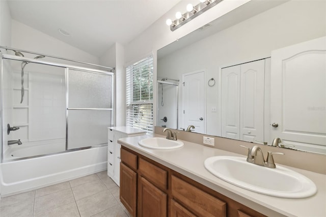 bathroom featuring vanity, vaulted ceiling, enclosed tub / shower combo, and tile patterned floors