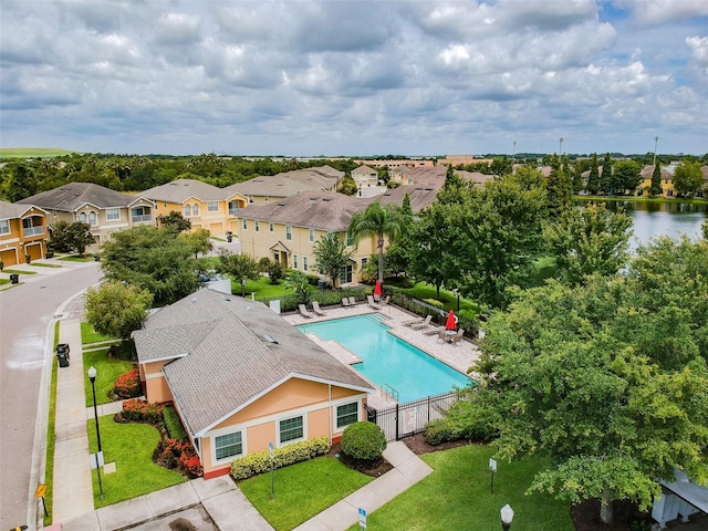 view of swimming pool featuring a water view, a yard, and a patio