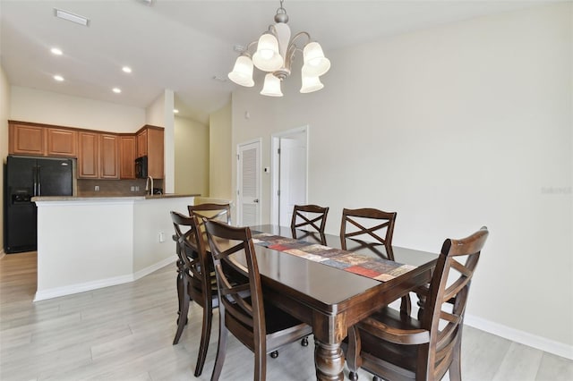 dining space with a notable chandelier and light hardwood / wood-style floors