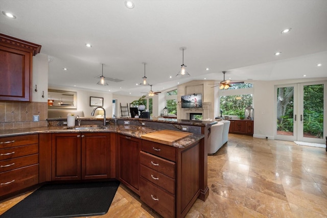 kitchen with french doors, decorative backsplash, sink, and stone countertops