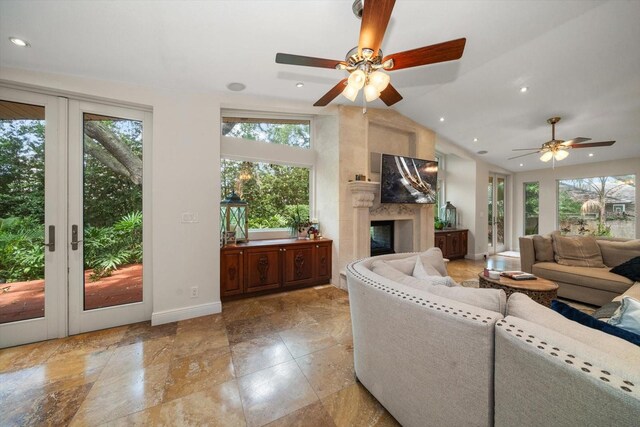 living room with vaulted ceiling, ceiling fan, and a premium fireplace