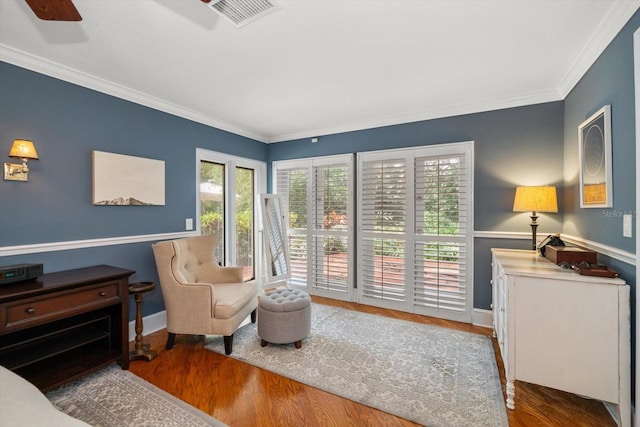 sitting room with dark hardwood / wood-style floors, ceiling fan, and crown molding