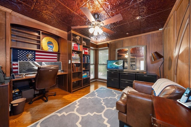 office featuring hardwood / wood-style floors, ceiling fan, ornamental molding, and wood walls