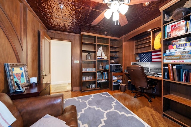 office space featuring ceiling fan, hardwood / wood-style floors, crown molding, and wood walls