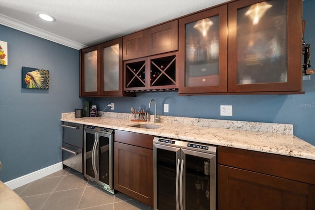 bar with light stone countertops, sink, beverage cooler, crown molding, and light tile patterned floors