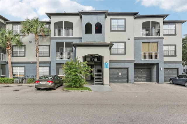 view of front of property featuring a balcony, cooling unit, and a garage