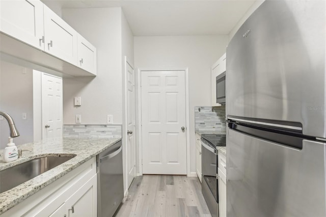 kitchen featuring light wood-type flooring, sink, stainless steel appliances, and white cabinets