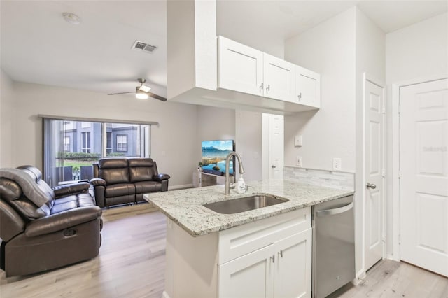 kitchen featuring light stone counters, dishwasher, sink, and white cabinetry