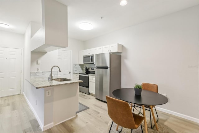 kitchen featuring stainless steel appliances, light wood-type flooring, sink, and white cabinetry