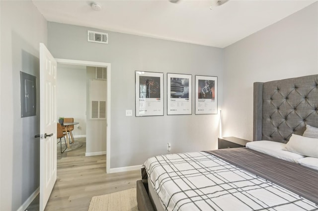 bedroom featuring light hardwood / wood-style flooring and electric panel