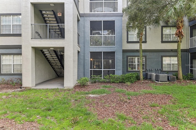 back of house featuring a lawn and central AC unit