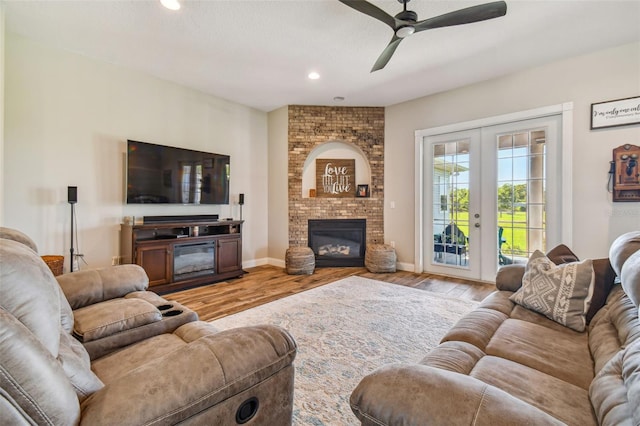 living room with light hardwood / wood-style flooring, a fireplace, and ceiling fan