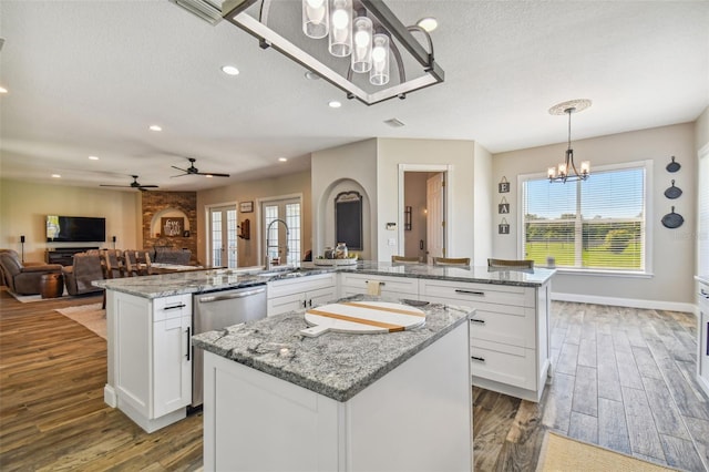 kitchen with a center island, decorative light fixtures, ceiling fan with notable chandelier, and white cabinets