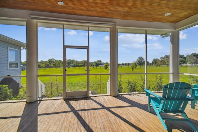 sunroom featuring a rural view, plenty of natural light, and wooden ceiling