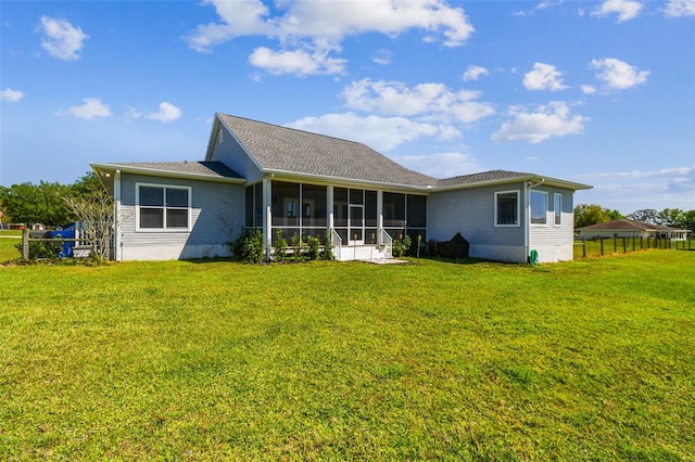 rear view of house with a yard and a sunroom