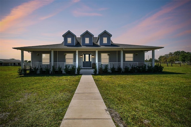 country-style home featuring a porch and a lawn