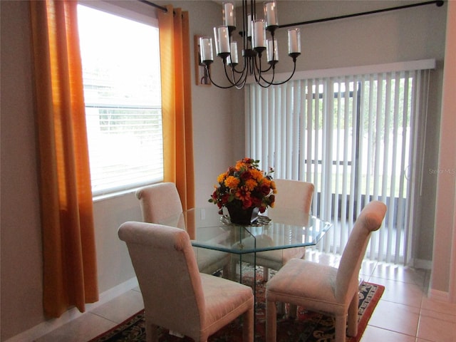 dining area with an inviting chandelier, light tile patterned flooring, and a healthy amount of sunlight