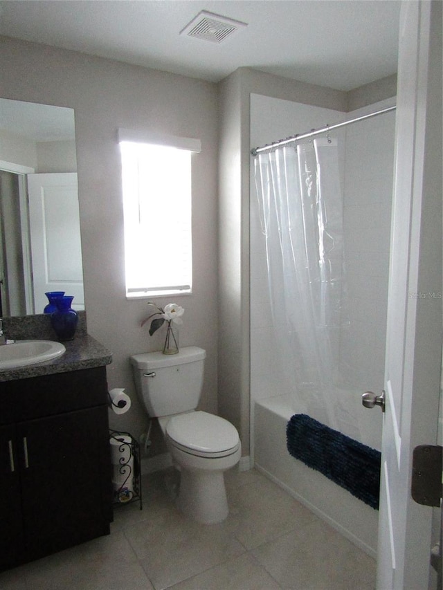 full bathroom with shower / tub combo with curtain, tile patterned flooring, vanity, and toilet