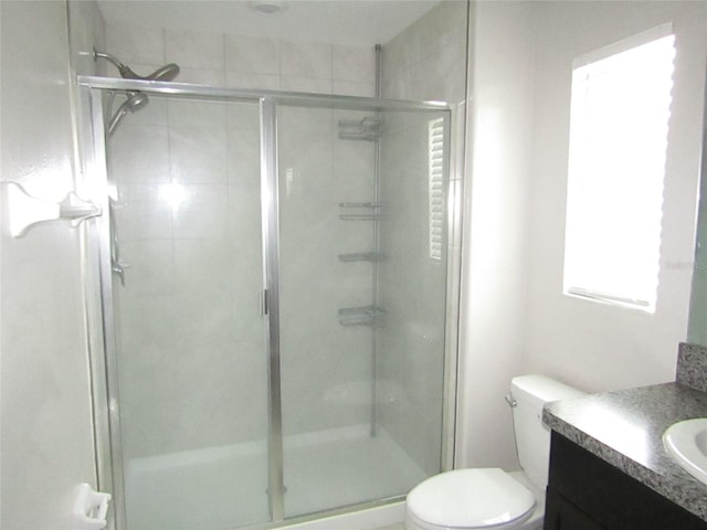 bathroom featuring vanity, toilet, and an enclosed shower