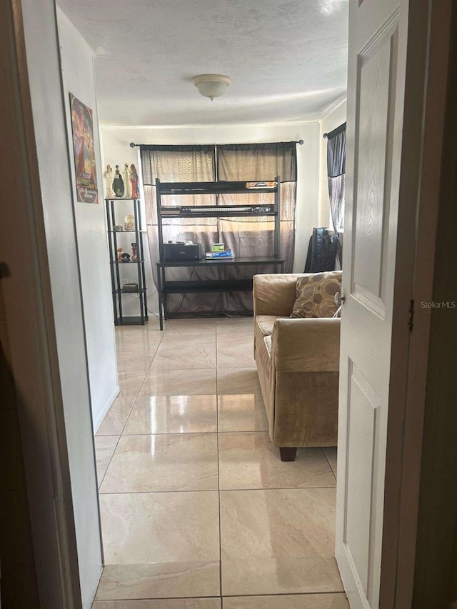 hallway featuring a textured ceiling and light tile patterned floors