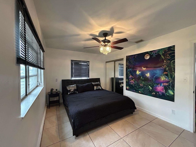 bedroom featuring ceiling fan, light tile patterned flooring, and a closet