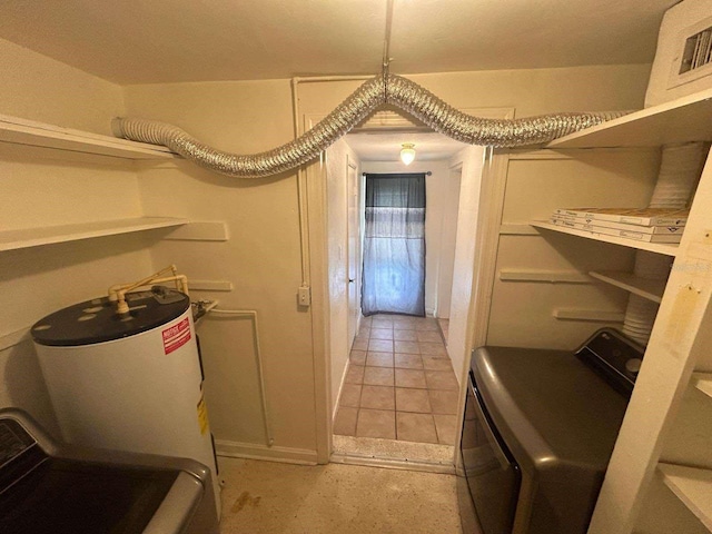 washroom featuring water heater and washer / dryer