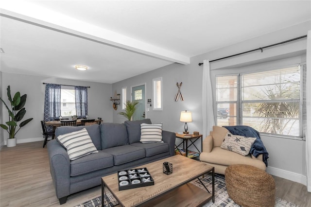 living room with beamed ceiling and light wood-type flooring