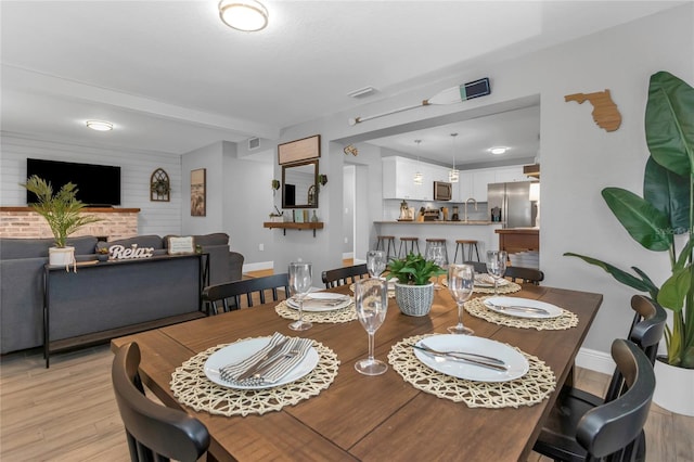 dining space featuring light hardwood / wood-style flooring, a fireplace, and sink