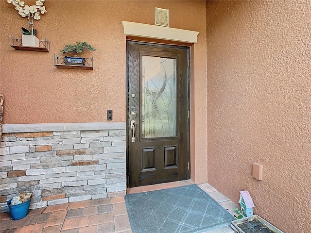 view of exterior entry with stucco siding