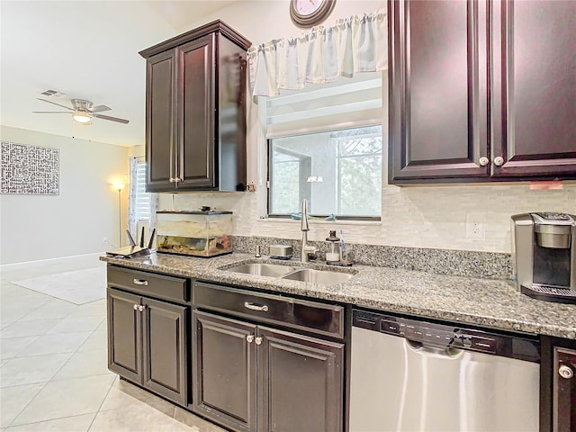 kitchen featuring a sink, tasteful backsplash, stainless steel dishwasher, and light tile patterned flooring