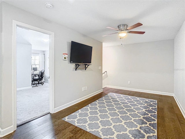 interior space featuring baseboards, dark wood finished floors, and a ceiling fan