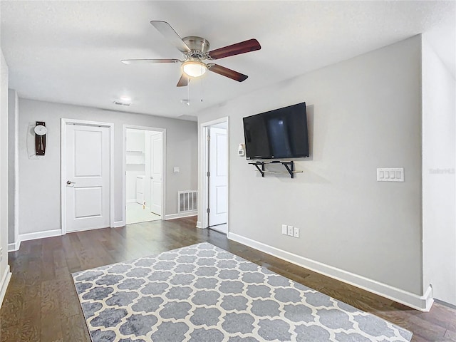 interior space with visible vents, ceiling fan, baseboards, and wood finished floors