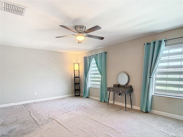 empty room featuring a ceiling fan, baseboards, visible vents, and carpet flooring