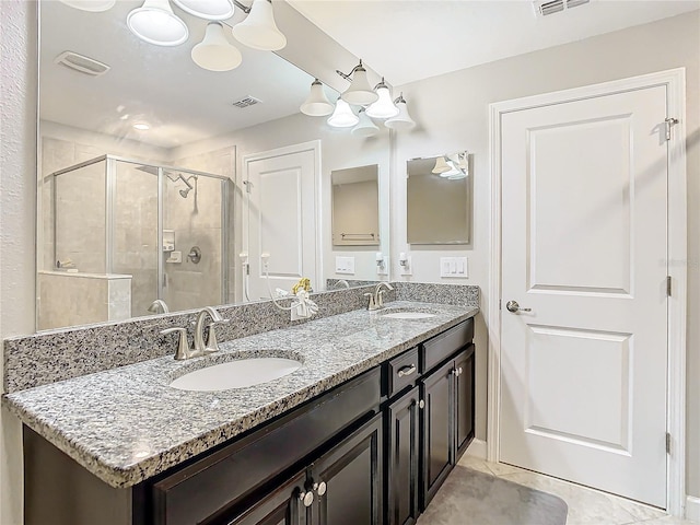 full bathroom featuring double vanity, a stall shower, a sink, and visible vents