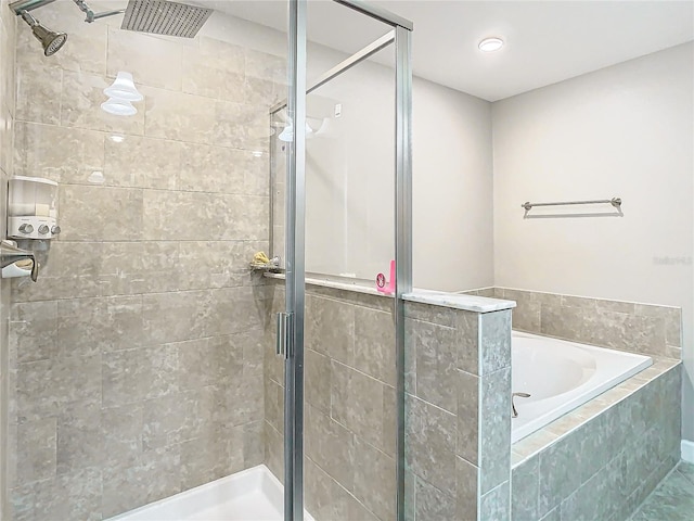 bathroom with a stall shower and a garden tub