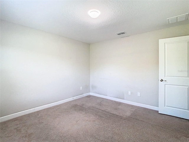 unfurnished room with carpet floors and a textured ceiling