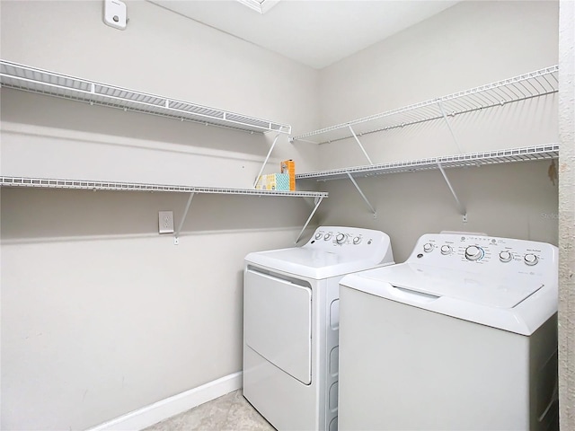 clothes washing area featuring washing machine and dryer, laundry area, and baseboards