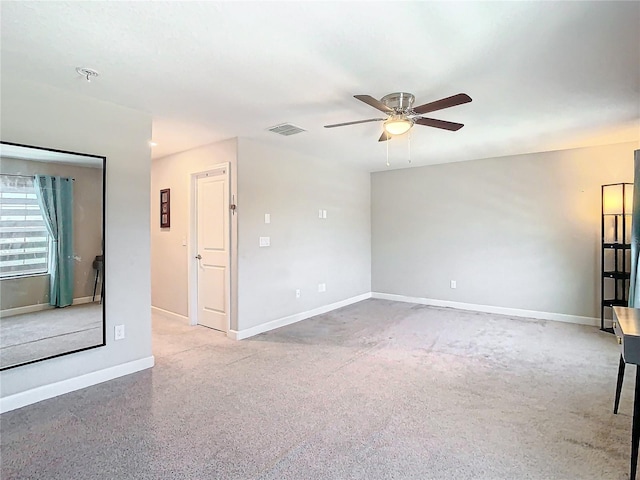 spare room featuring a ceiling fan, visible vents, and baseboards