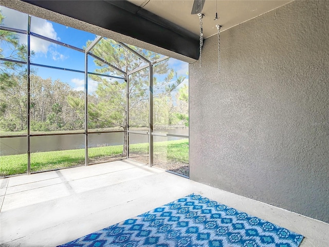 unfurnished sunroom featuring a water view