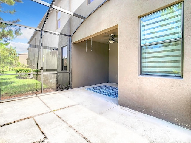 exterior space with a ceiling fan and glass enclosure